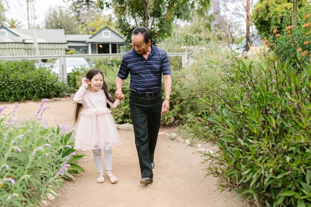 Uomo asiatico mano nella mano con una bambina